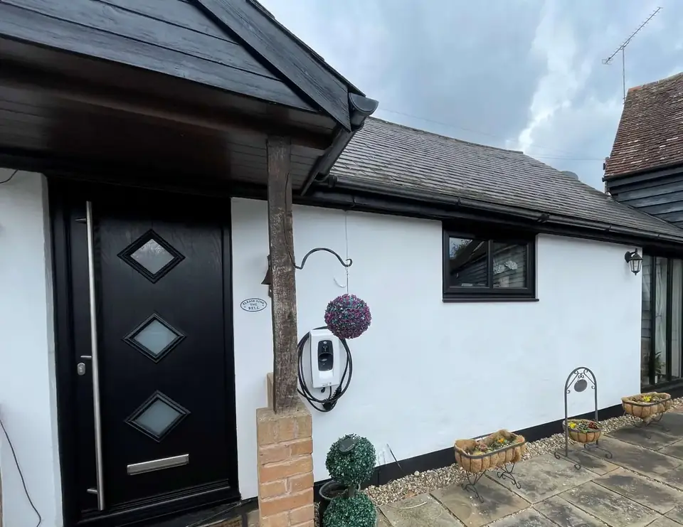 Black composite door with diamond glazing fitted on a white cottage