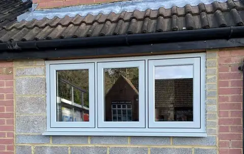 A grey flush casement window in new brickwork